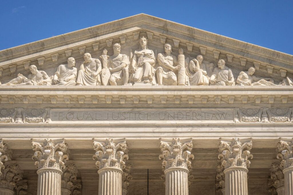 Detailed view of the Supreme Court Building's frontal frieze depicting historical figures and justices.